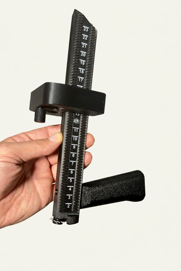Hand holding BoxPal Pro 2.0, showing the numbered 2 to 23 scale on the back of the tool