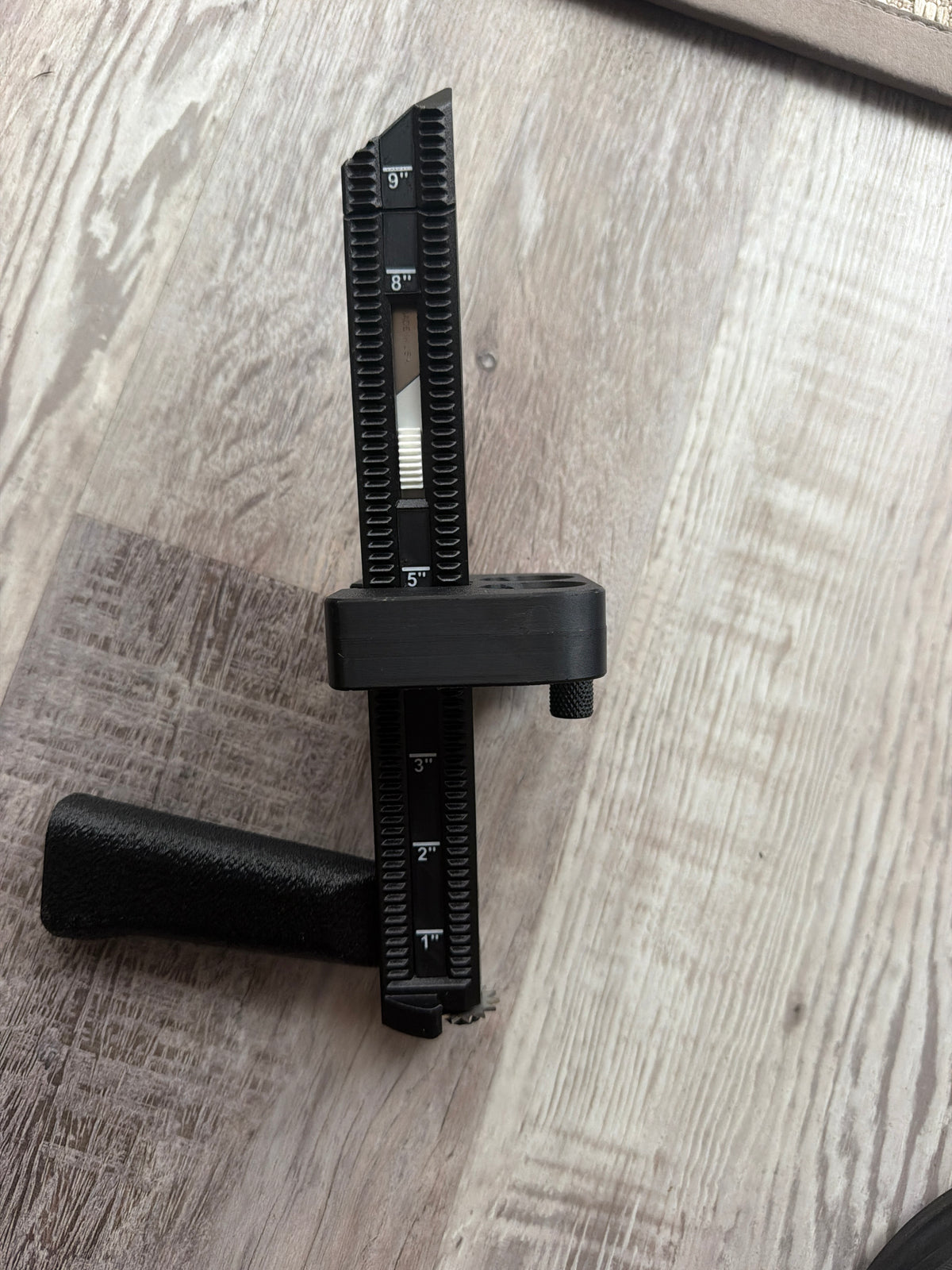 Close-up of the BoxPal Pro 2.0 depth guide markings, positioner, and grip on a wood floor
