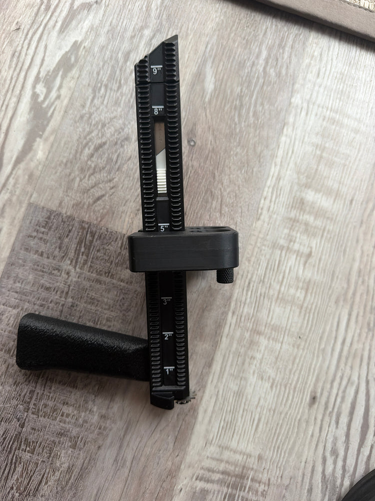 Close-up of the BoxPal Pro 2.0 depth guide markings, positioner, and grip on a wood floor