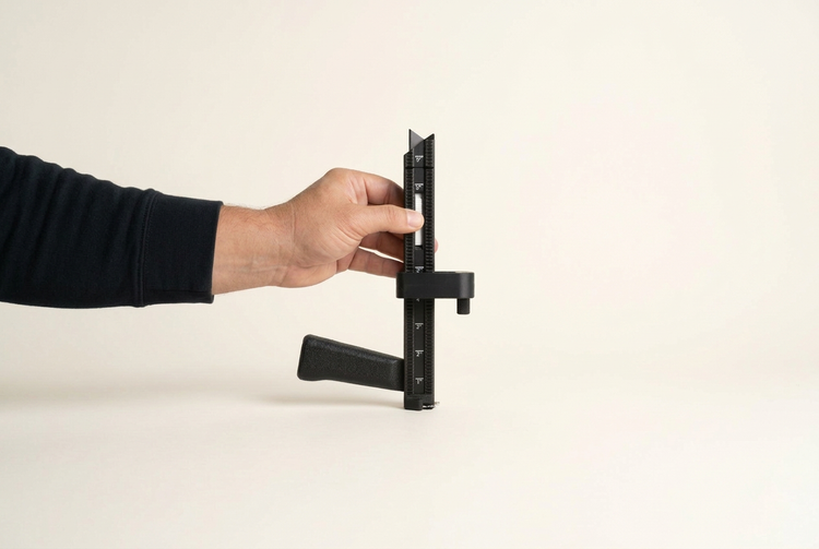 Hand setting the BoxPal Pro 2.0 positioner on the depth guide to match a product's height